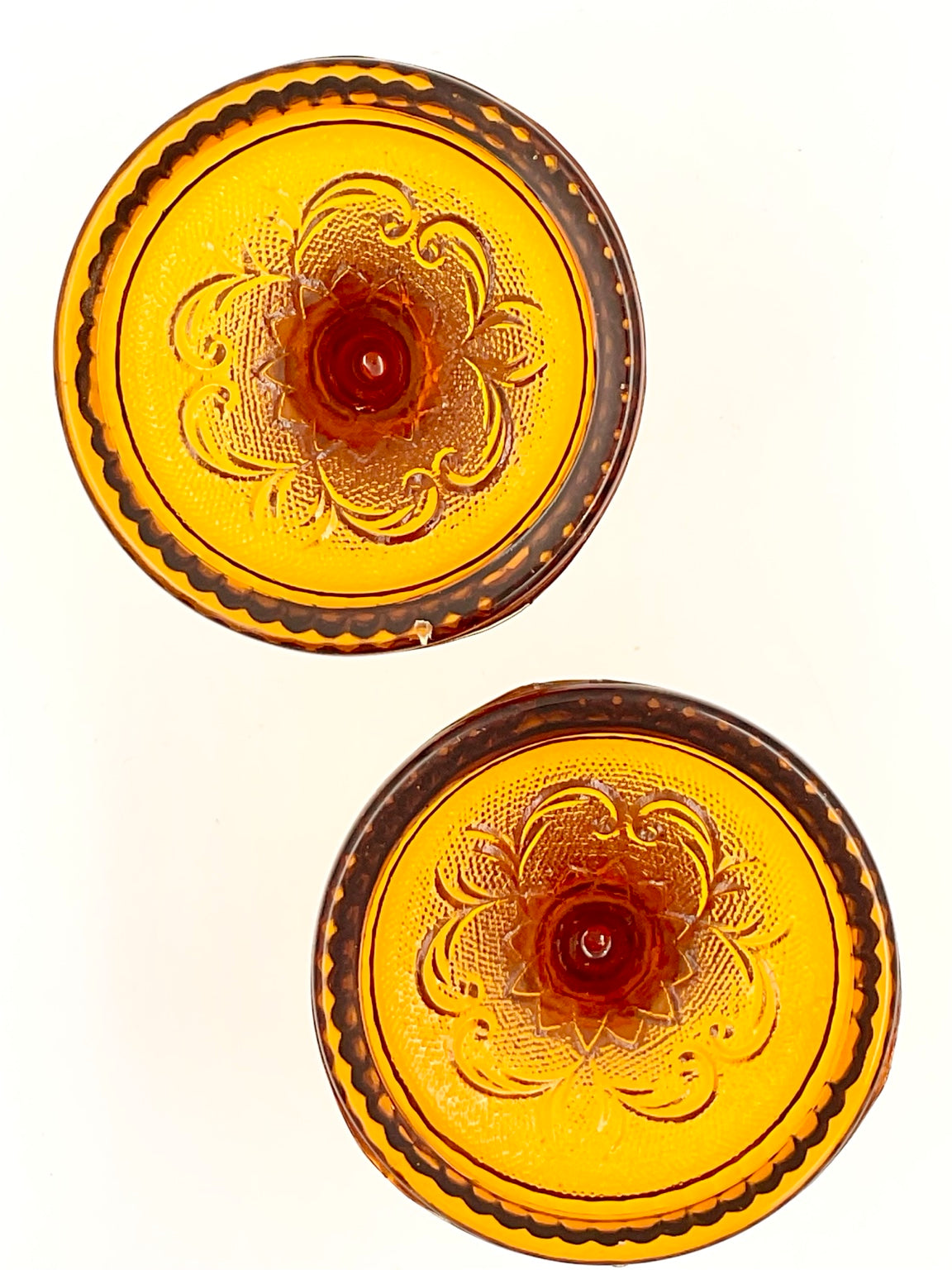 Undersides of amber candle holders showing base edge detail