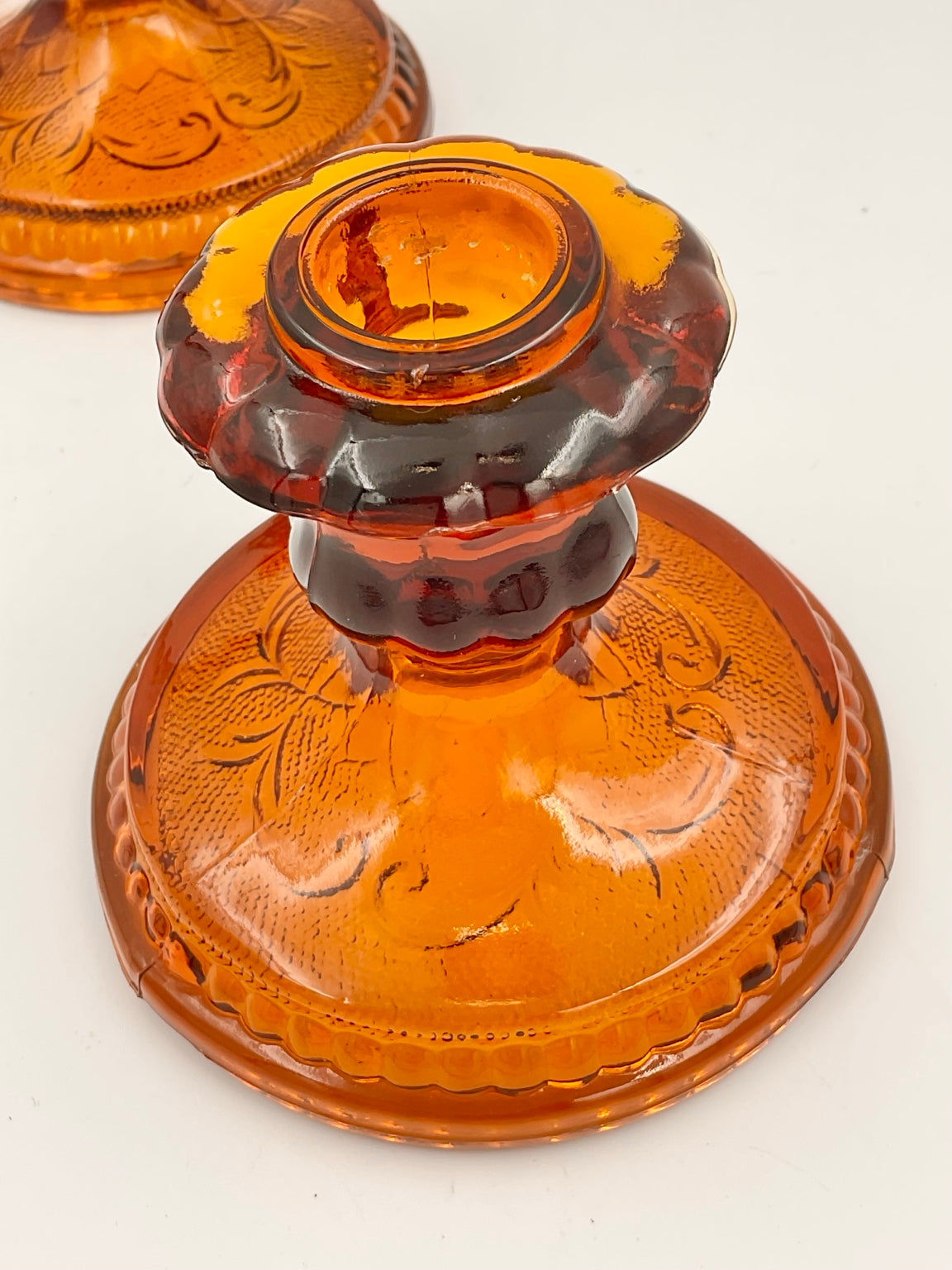 Detail of amber candle holder candle cup and patterned base
